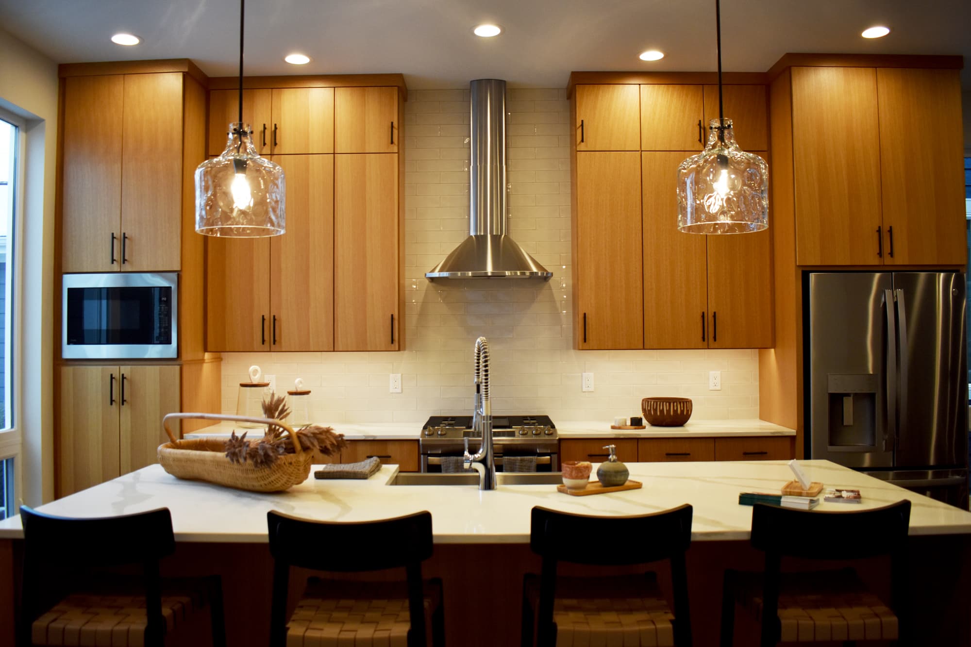 Custom kitchen with glass pendant lights and warm oak cabinetry, electrical by Greatland Electric in Southeast Wisconsin